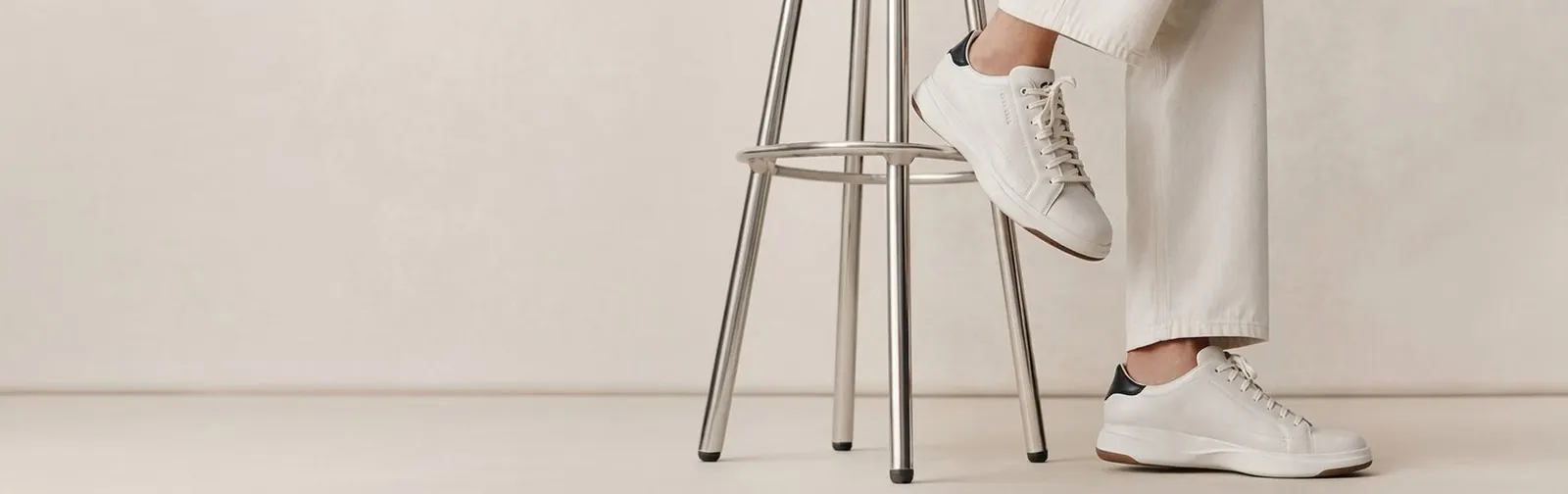White leather sneakers beside a bar stool